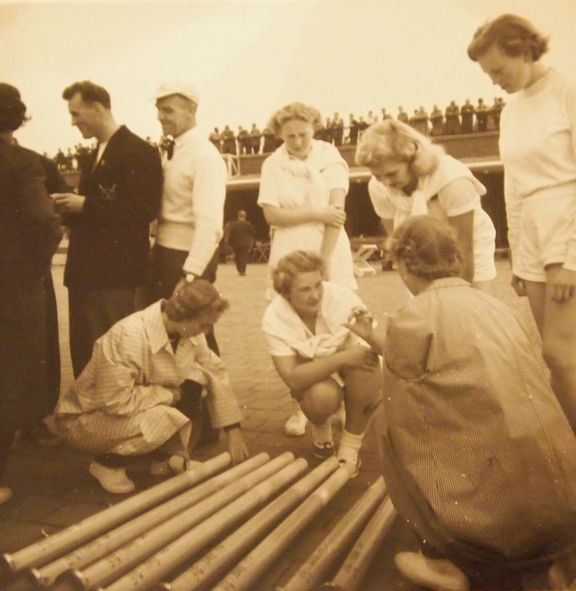 Sepia photo of women looking at rowing oars on the ground