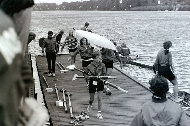 Women carrying boat on landing stage