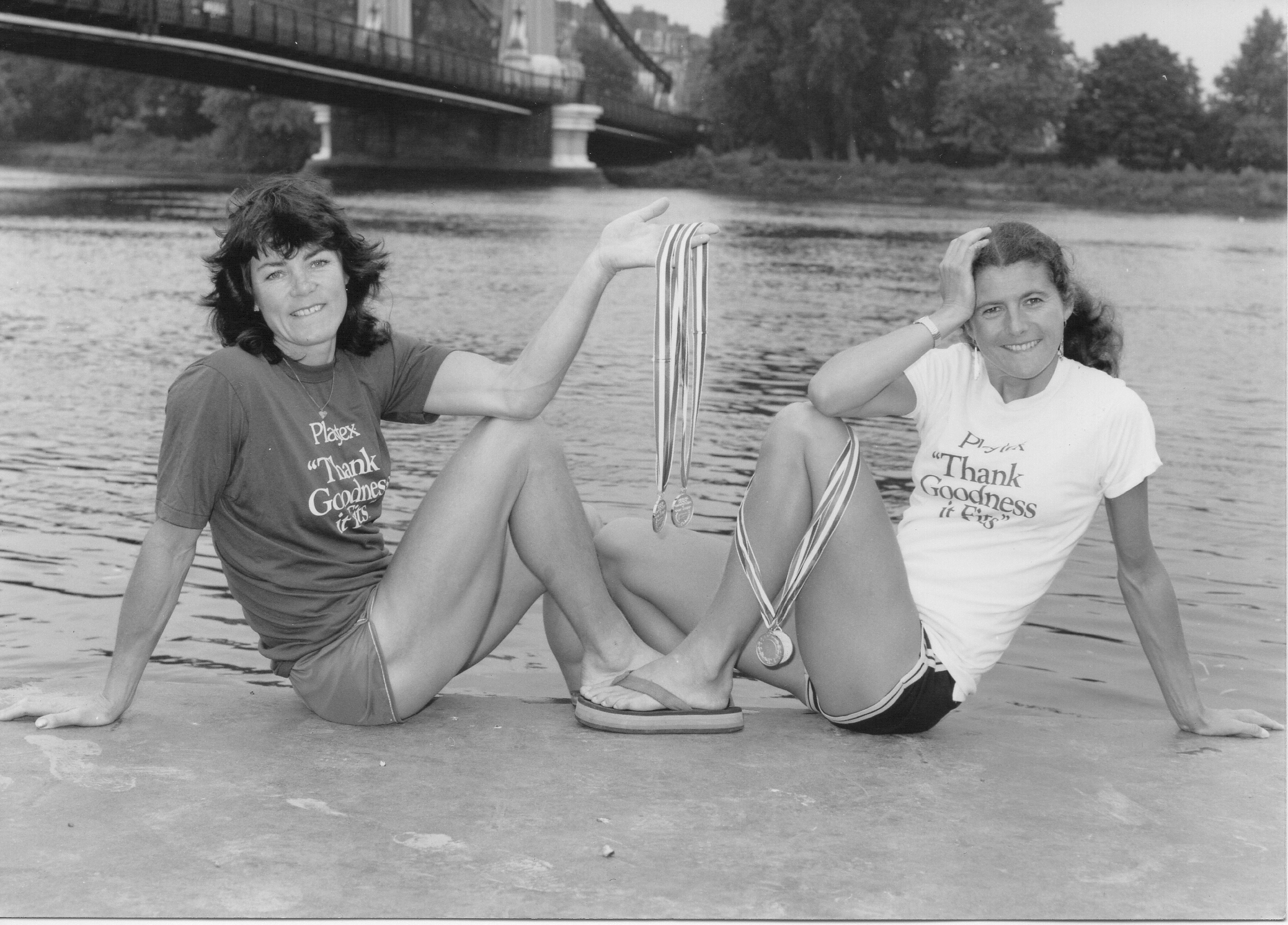 Lin and Beryl sitting on a landing stage with medals
