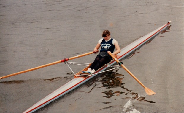 Young woman sculling in Bradford ARC vest