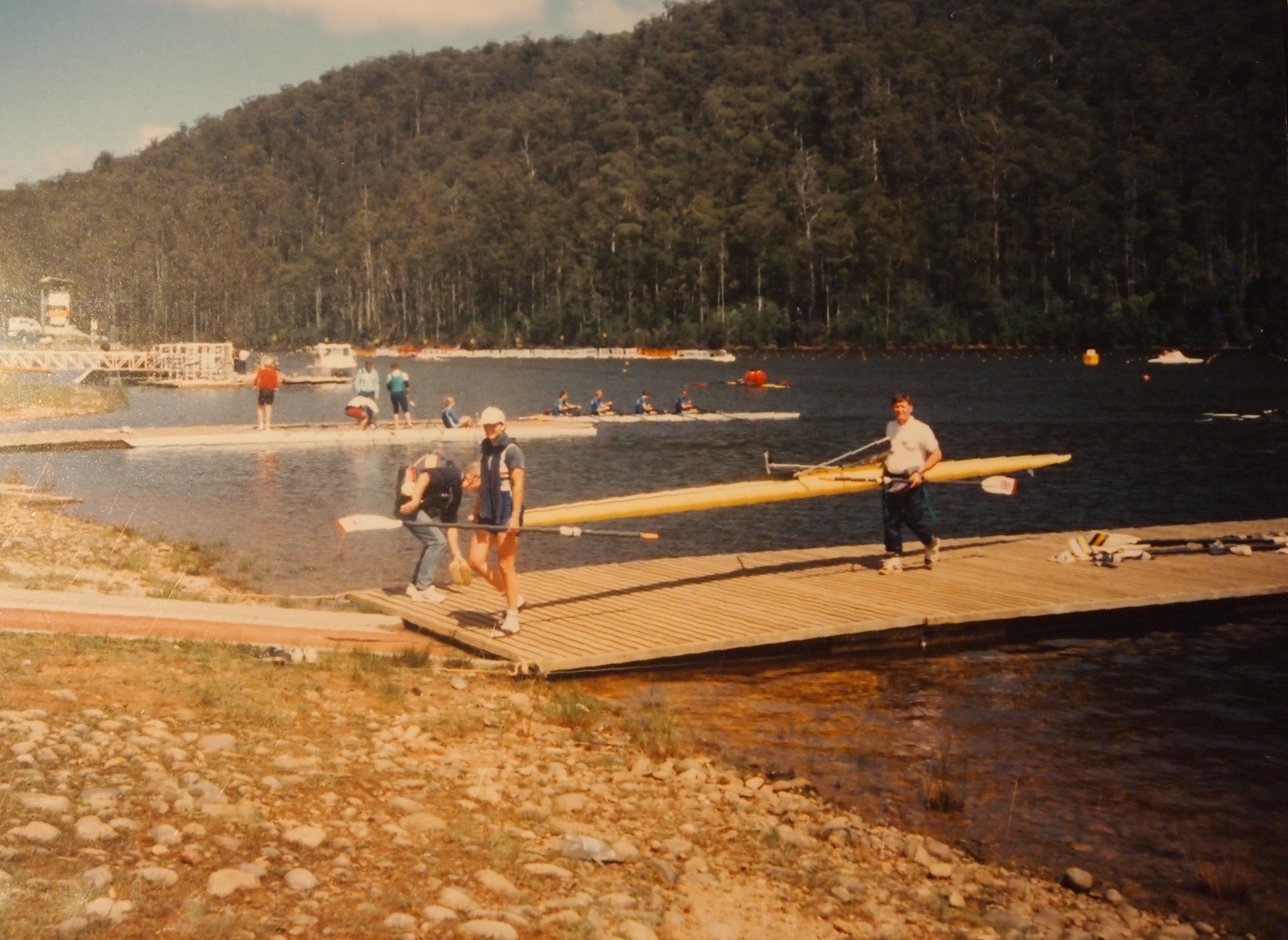 Sculler and coach carrying boat.