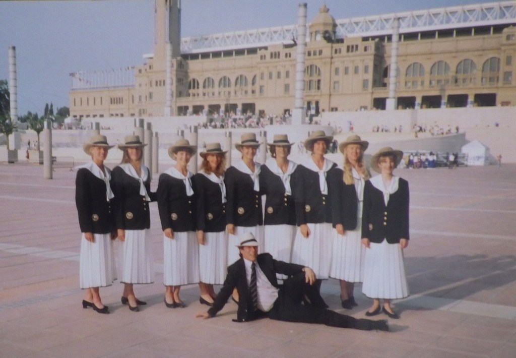 9 women in white skirts and navy blazers