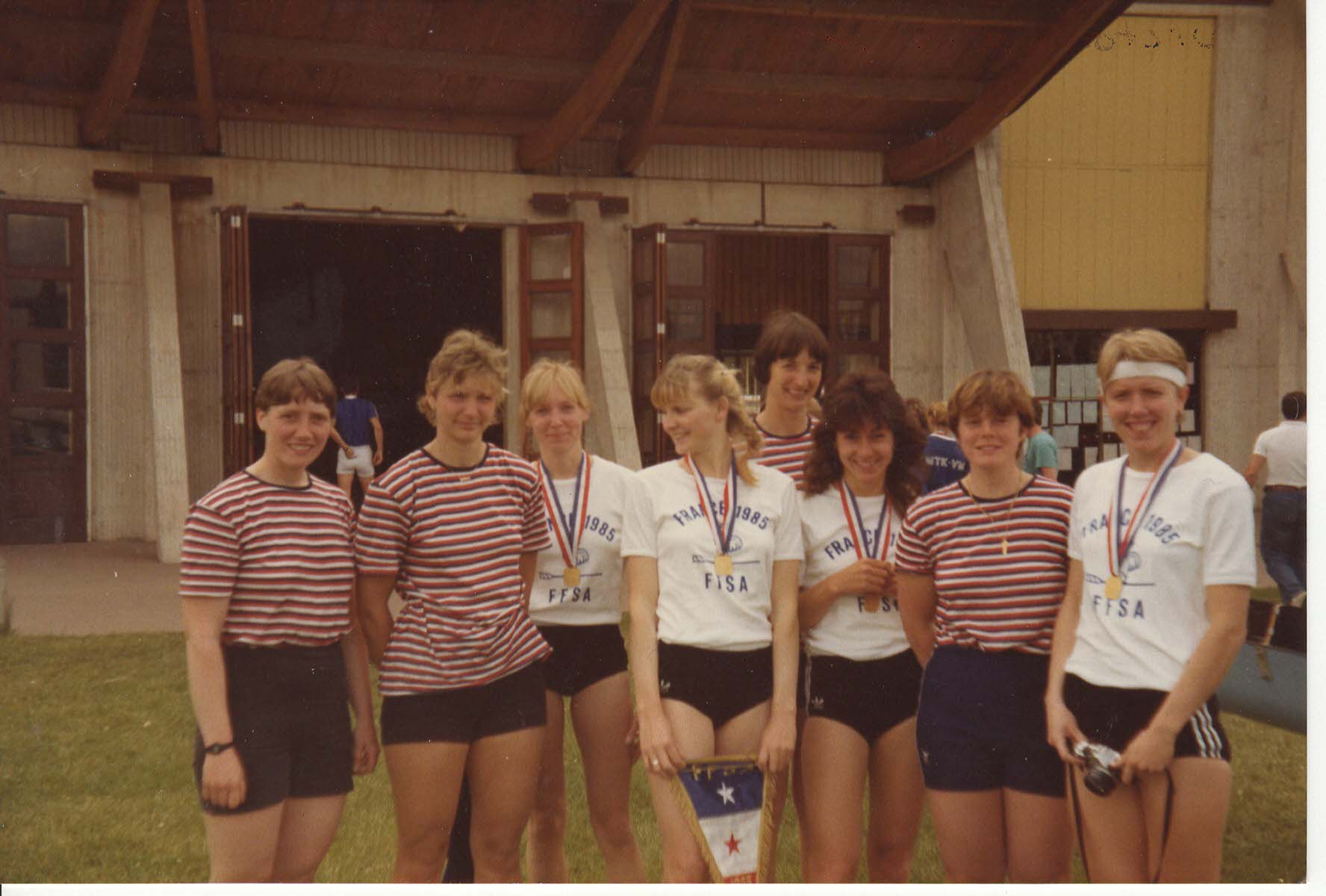8 women in front of boathouse