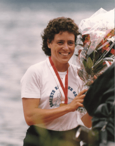 woman with medal and bouquet of flowers