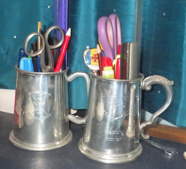 Pewter pots with pens and rulers in