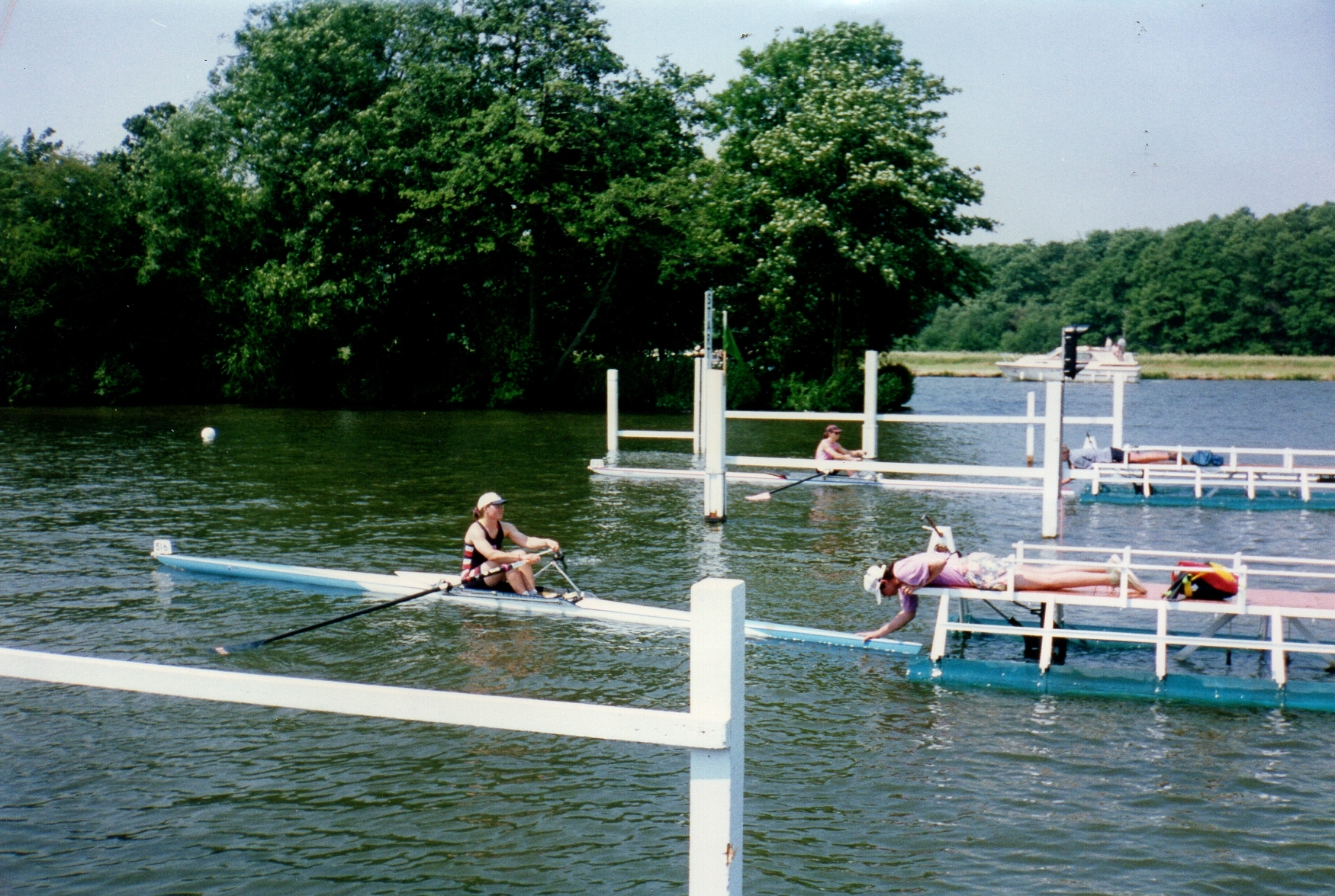 two women scullers on start with trees in background