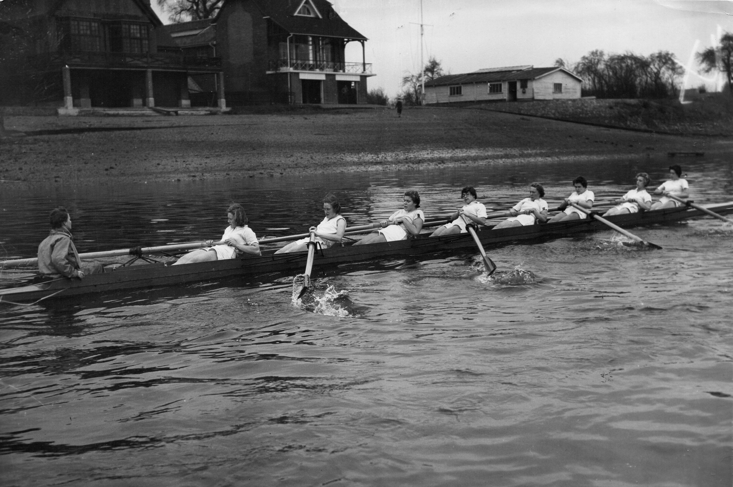 Women's eight leaning back at the finish passing Ibis and Quintin