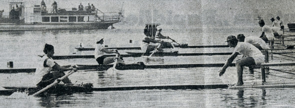 Black and white photo of 4 women starting sculling race