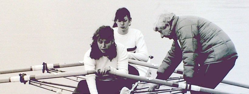 bw photo of 2 women boating in double scull with male coach