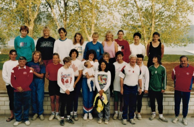 Women's team in mixed kit with coaches