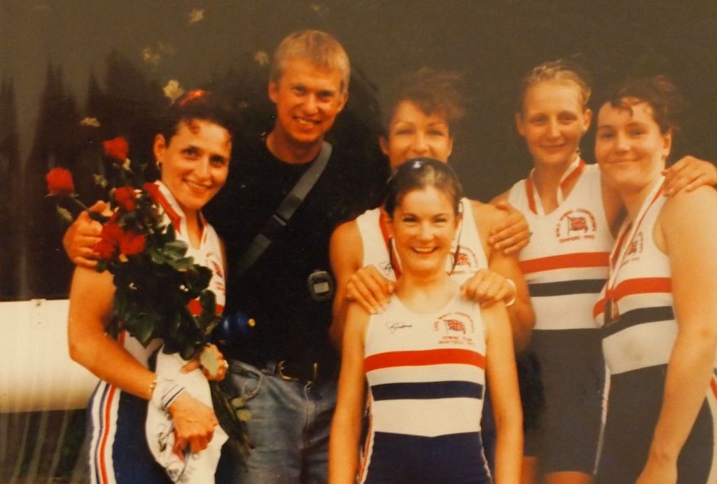 5 women and coach with medals and red roses