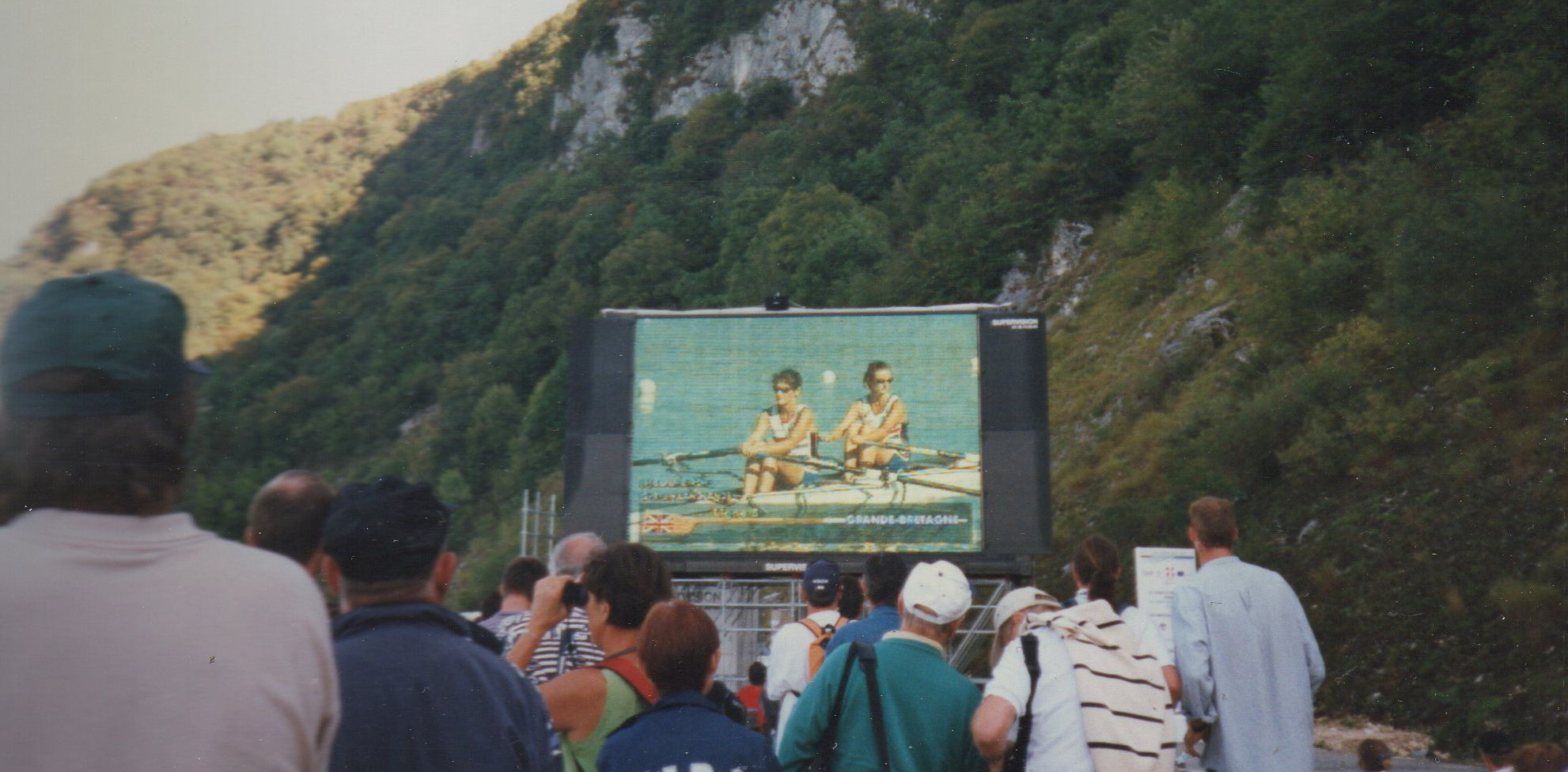 crowd with big screen showing racing
