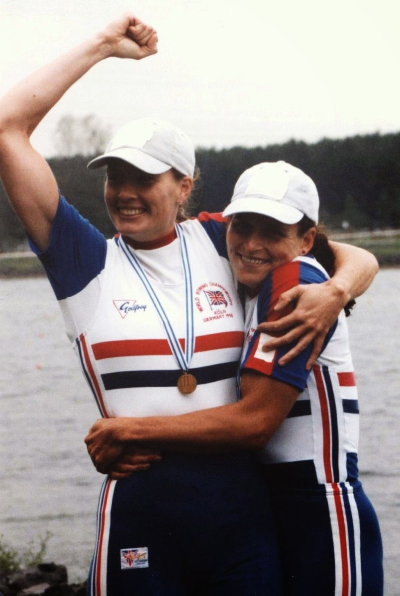 Two women hugging and looking happy with medals