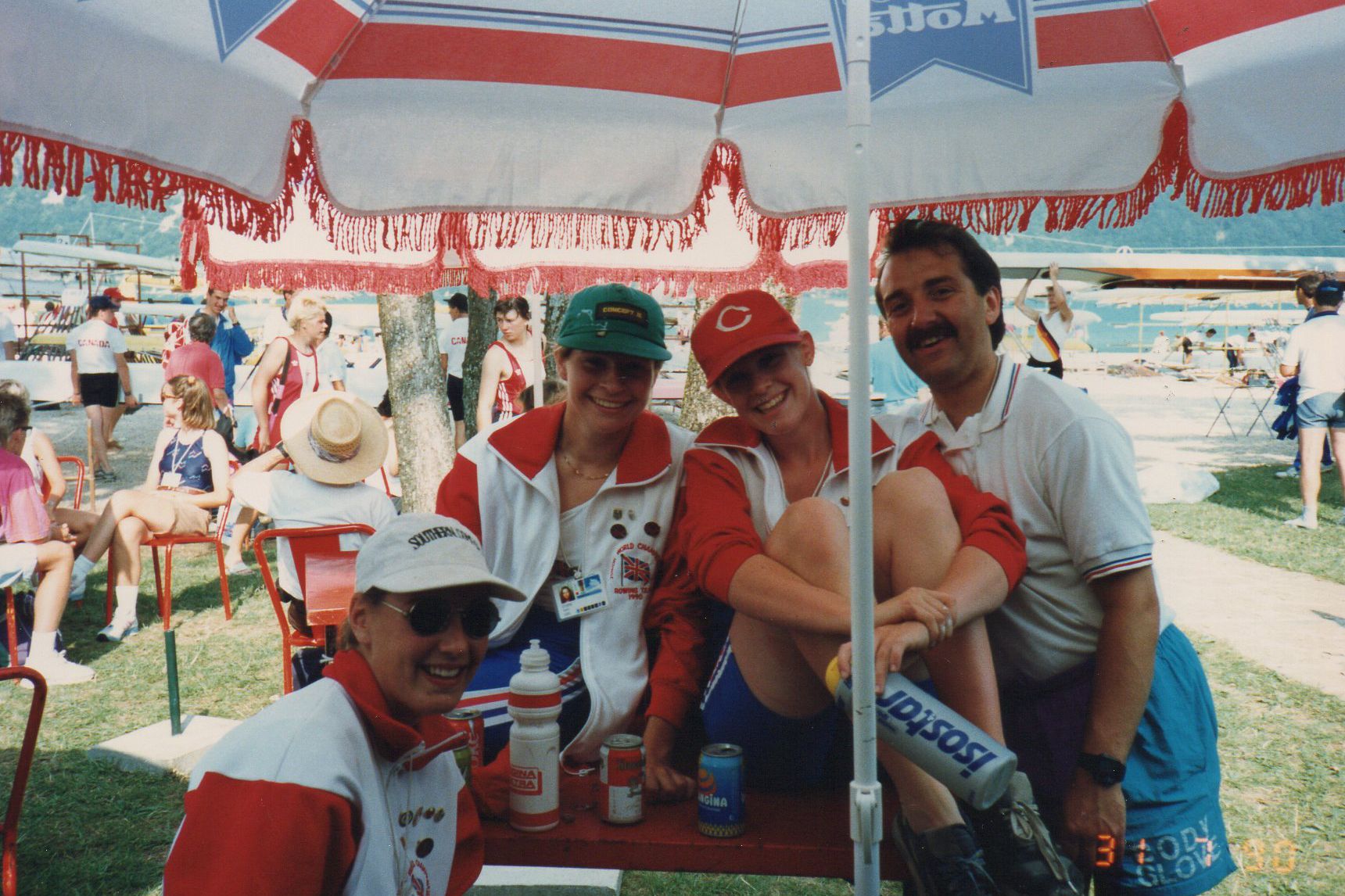 3 girls and coach at table under umbrella