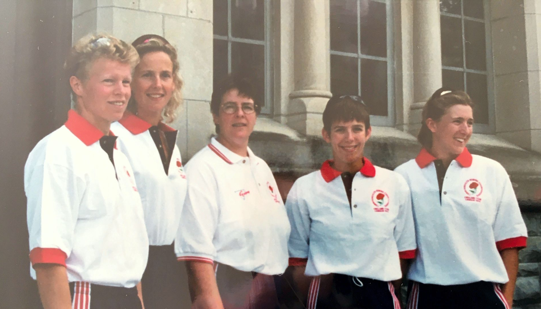 5 women wearing white polo shirts with England red roses on