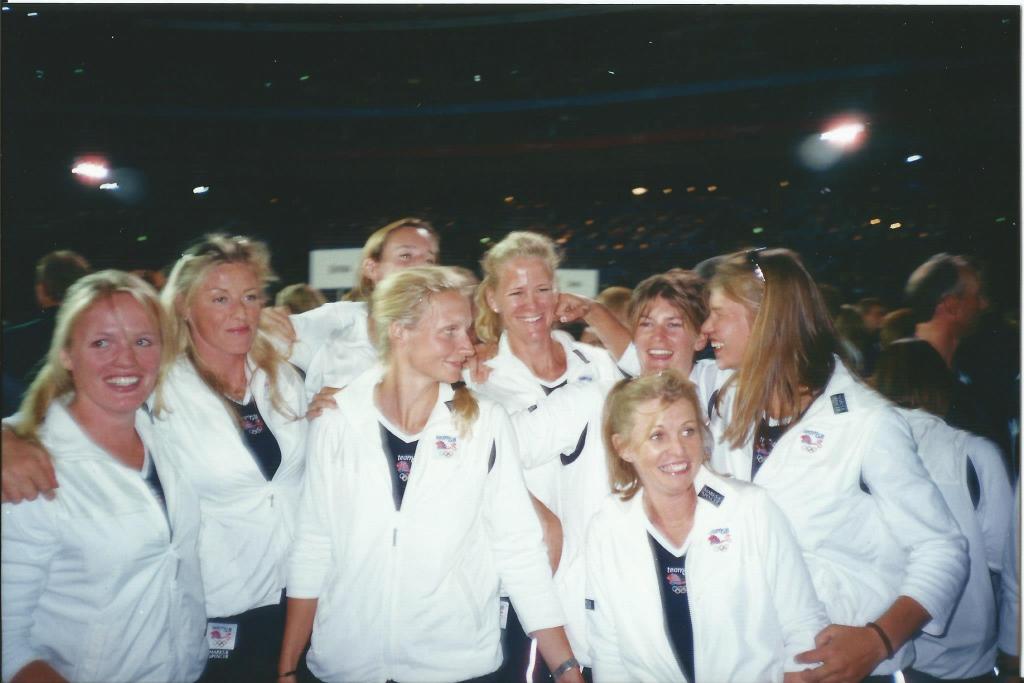 Women in white tracksuit tops in dark stadium