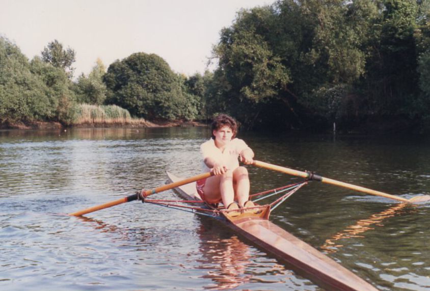 Woman in sculling boat in red shorts