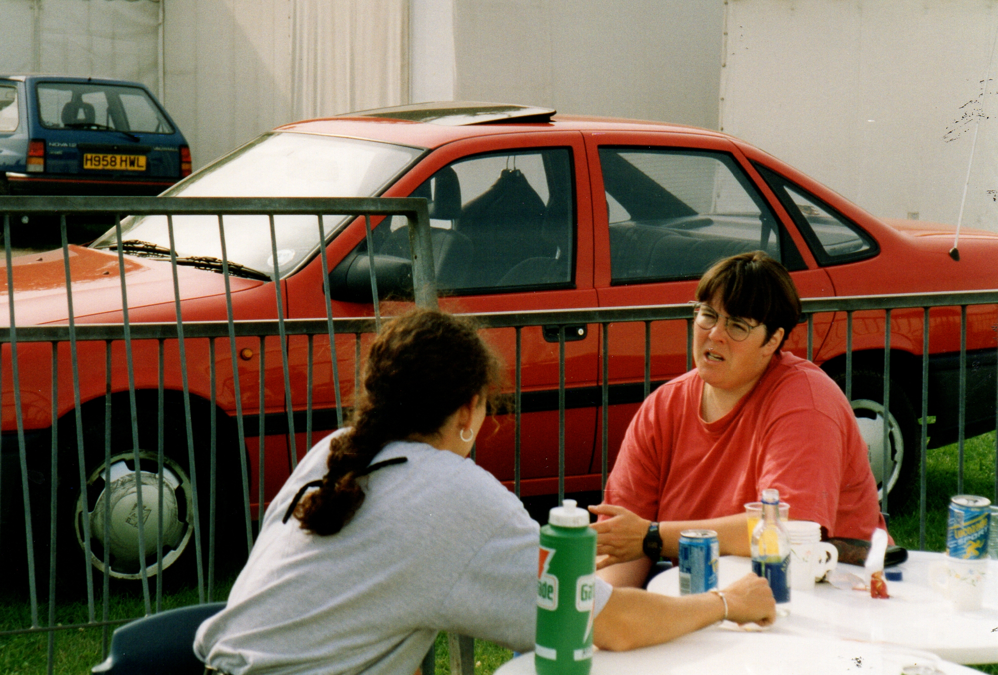 Coach in red t-shirt talking to sculler in grey t-shirt