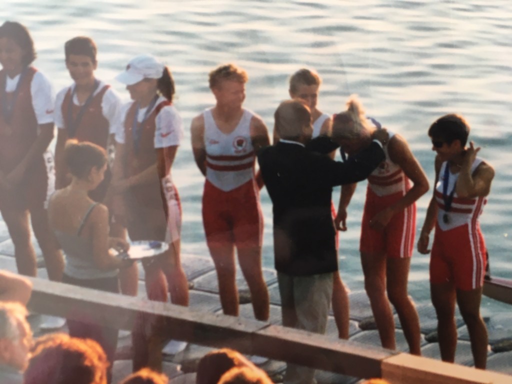 women in red shorts being presented with silver medals on raft