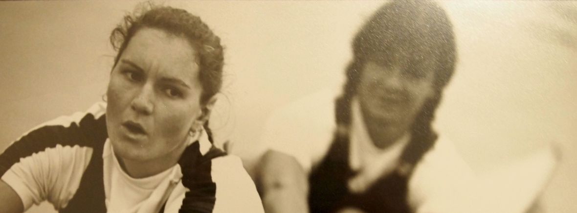 Black and white photo of two women concentrating while rowing