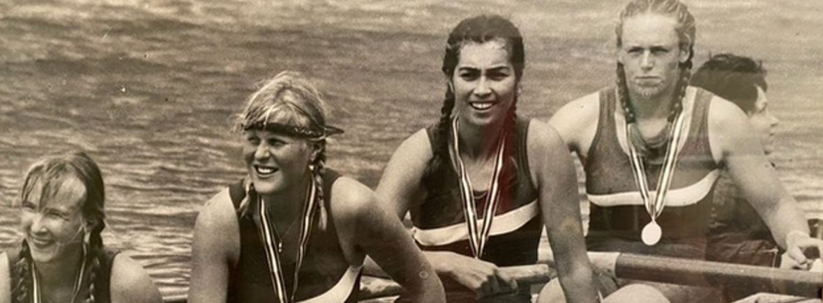 b/w photo of 4 women in coxed four with medals