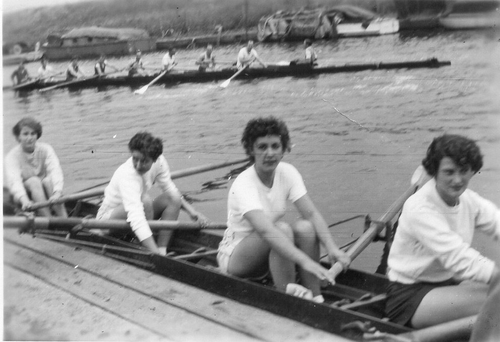Women's four on landing stage with men's eight in background